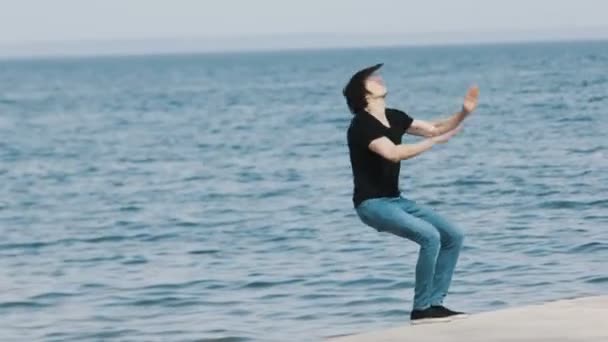 Gars faisant backflip de jetée sur la plage — Video