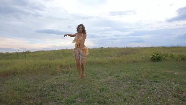 Сексуальная девушка в костюме для сальсы профессионально танцует в поле на закате — стоковое видео