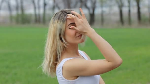 Souriant Fille attrayante au jardin regardant par-dessus son épaule à la caméra . — Video