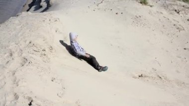 Çocuk slaytlar kumlu bir tepeden aşağı