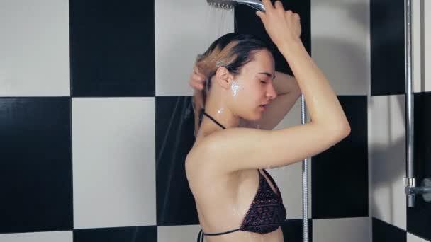 The girl washes her hair. take a shower in the bathroom. The shampoo on the hair — Stockvideo