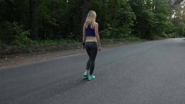 Sexy bionda passeggiando lungo la strada nella foresta. Girato con steadicam — Video Stock