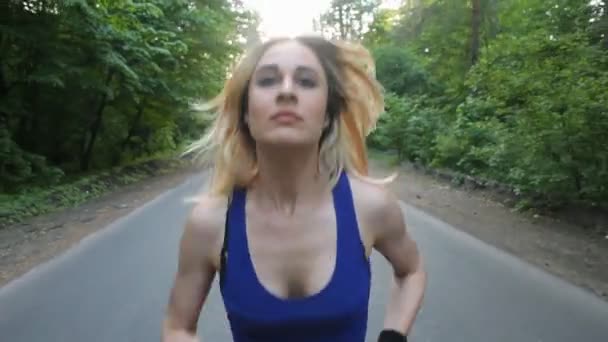 Uma mulher corredora a correr na estrada, na floresta. fitness ao ar livre. tiro com steadicam — Vídeo de Stock