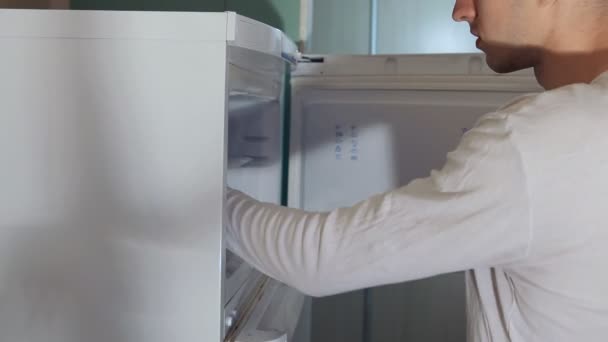 El hombre toma carne del refrigerador — Vídeo de stock