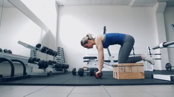 Κορίτσι κάνει άσκηση για γυμναστήριο γυμναστήριο προπόνηση με τον κύλινδρο ρόδα Exerciser — Αρχείο Βίντεο