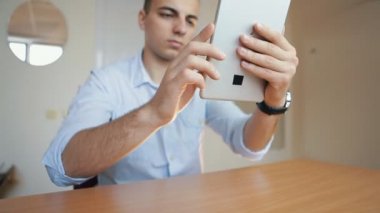 adam bir tablet kullanarak fotoğraf yapar