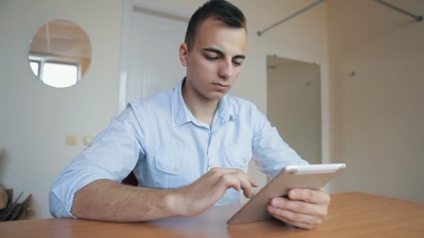 Jeune homme d'affaires avec tablette informatique au bureau — Video