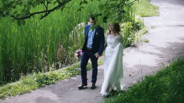 Fit y feliz pareja joven caminar por el parque — Vídeos de Stock