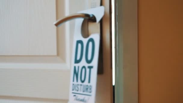 На двери гостиничного номера висит табличка "Не беспокоить" — стоковое видео