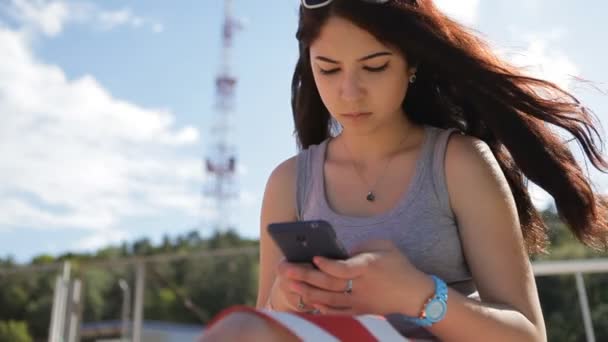 触摸屏的现代智能手机在海滩的女孩. — 图库视频影像