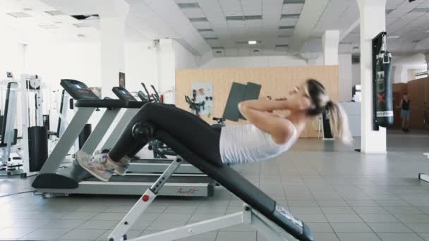 Atletisk flicka i gym göra Sit Ups på Roman Chair — Stockvideo