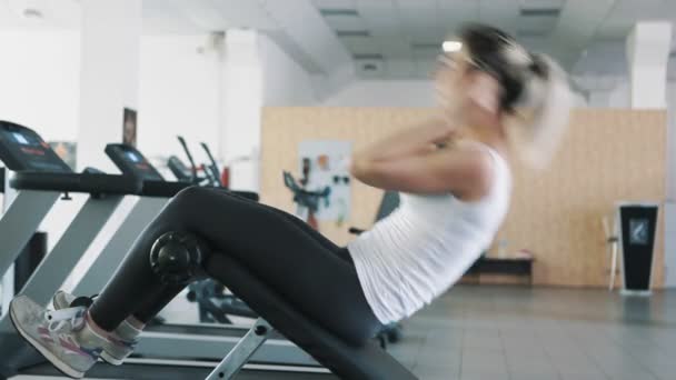 Atletisk flicka i gym göra Sit Ups på Roman Chair — Stockvideo