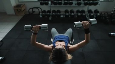 spor salonunda atletik kız ne bir eğik bankta dumbbell press