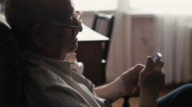 evde bir cep telefonu kullanarak yaşlı bir adam portresi