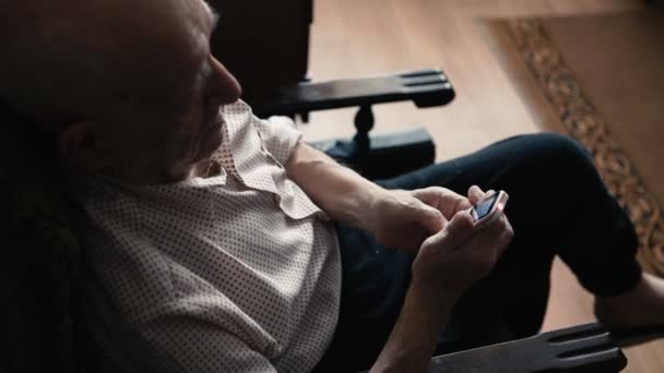 Retrato de homem muito velho usando um telefone celular em casa — Vídeo de Stock