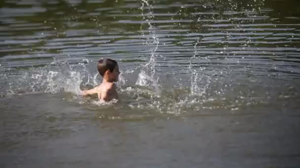 Vidám fiú pisilés víz — Stock videók