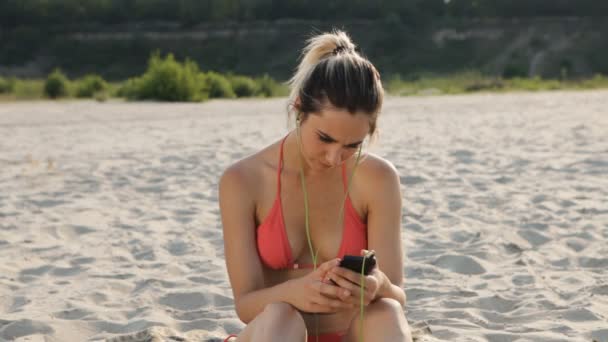 Смартфон жінка смс-повідомлення, використовуючи додаток на смартфон на пляжі — стокове відео