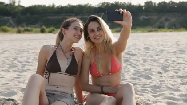 Iki çekici kızlar sahilde selfie yapıyor — Stok video