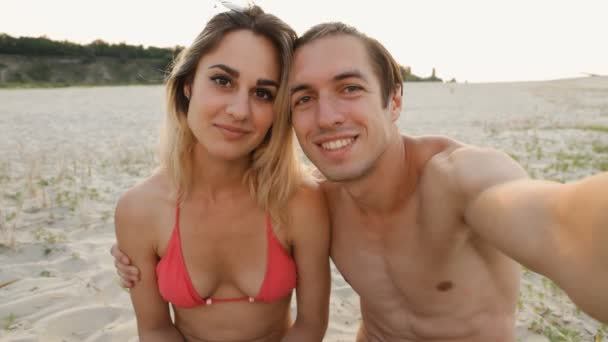 年轻幸福的夫妇在日落时分做自拍照在沙滩上 — 图库视频影像