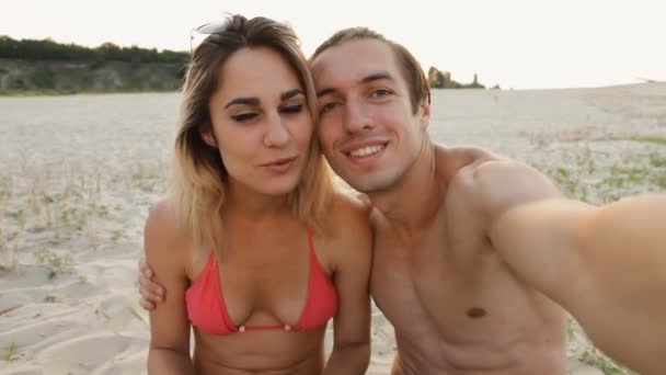 Jovem casal fazendo selfie na praia ao pôr do sol — Vídeo de Stock