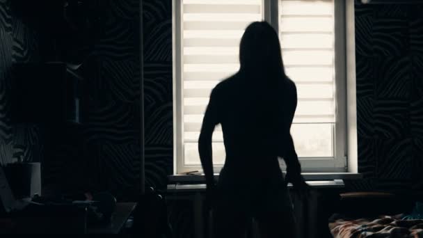 Силуэт танцовщицы, танцующей перед окном дома — стоковое видео