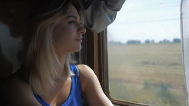 Kadın pencereden dışarı bakarak bir tren seyahat