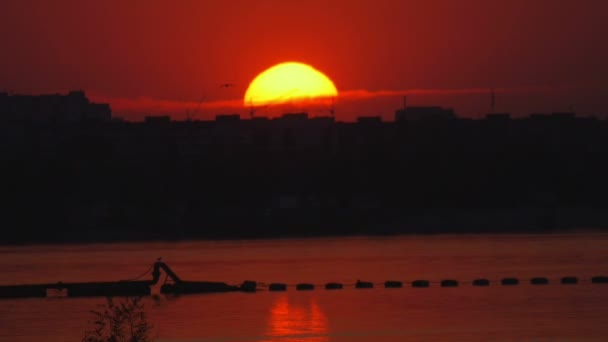 海と街の背景に沈む夕日 — ストック動画