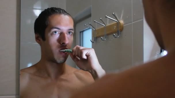 Hombre cepillándose los dientes en el baño — Vídeos de Stock