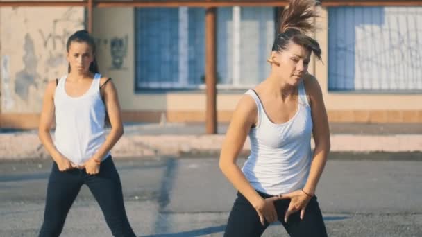 Mädchen in weißen T-Shirts tanzen in Zeitlupe auf dem Spielplatz — Stockvideo