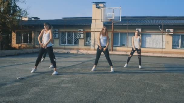 Mädchen in weißen T-Shirts tanzen in Zeitlupe auf dem Spielplatz — Stockvideo