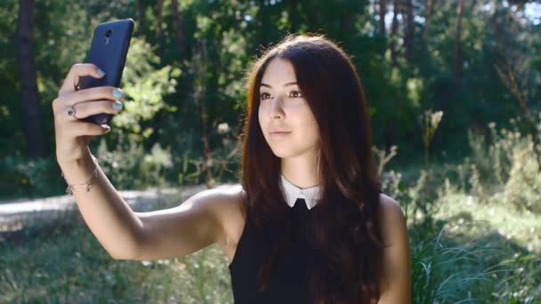 Chica caucásica haciendo selfie en su teléfono inteligente al aire libre — Vídeo de stock