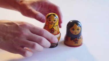Adam 4 k beyaz bir arka plan üzerinde Matryoshka bebek ayrıştırır