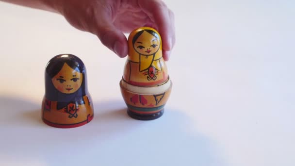 Man parses Matryoshka Doll on a white background in 4k — Stock Video