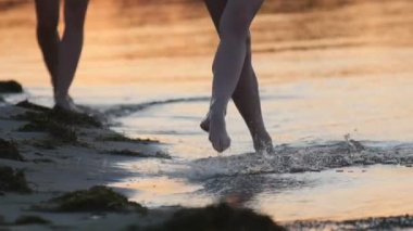 Okyanus sığlık tarafından yürüyüş grubu genç kızların çıplak bacaklar ayak