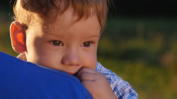 Primer plano de un padre sosteniendo a su hijo pequeño en sus brazos — Vídeo de stock