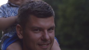 Babalar omuzlarında oturan bir yaşında yakışıklı