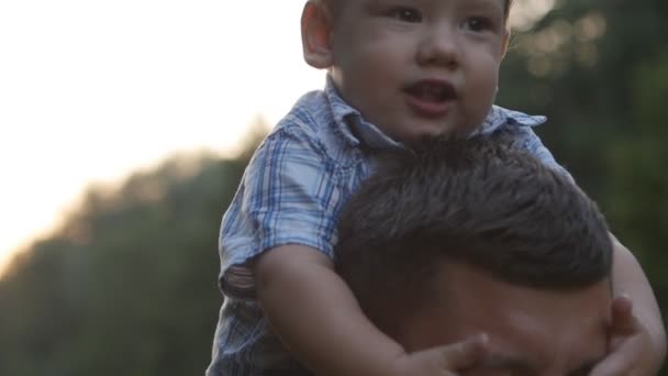 Menino sentado nos ombros dos pais — Vídeo de Stock