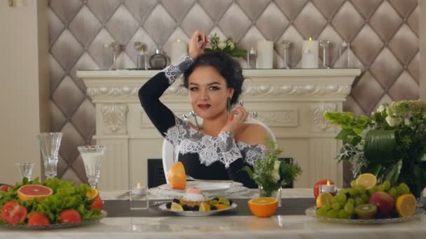 Модель брюнетки леди за столом с фруктами позирует на камеру — стоковое видео