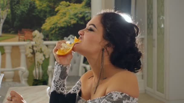 Девушка ест грязный апельсин в замедленной съемке — стоковое видео