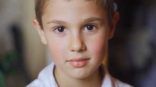 Portréja egy aranyos fiú nagy szemekkel néz a kamerába — Stock videók