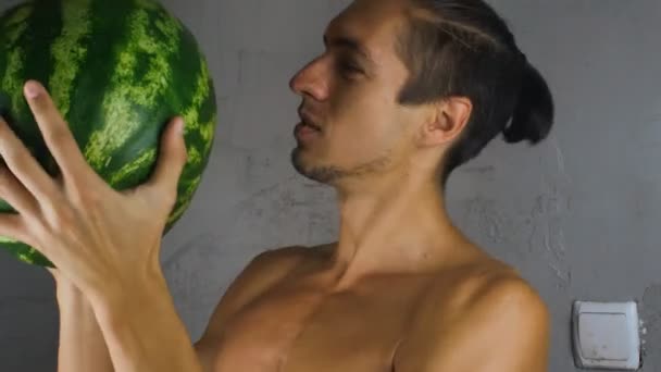 Homem segurando uma melancia e examina-lo — Vídeo de Stock