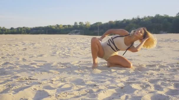 Sexy chica bailarina profesional practicando en la playa en la arena al atardecer — Vídeos de Stock