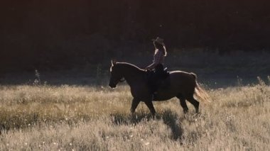 Ağır çekimde gün batımında Prairie at binme şapkalı güzel kız
