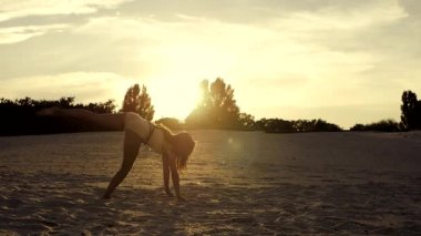 seksi kız kum üzerinde ileri favorilerden günbatımında yapıyor