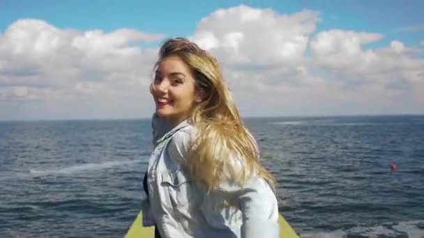 Дівчина з довгим волоссям біжить до моря, стріляючи на стедікамі — стокове відео
