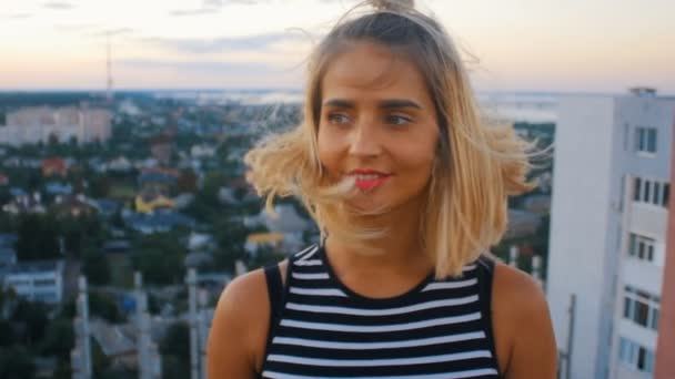 Porträtt av en glad kvinna på en bakgrund av en liten stad — Stockvideo