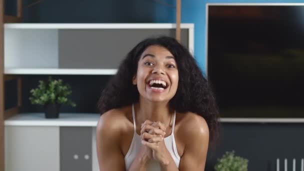 Spännande afrikansk-amerikansk kvinna som visar ja-gest. Glad lotteri flicka vinnare firar framgång, förvånad över kameran, sitter hemma lägenhet. Segerkoncept. — Stockvideo