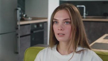 Şok olmuş ve şaşırmış genç bir kadının portresi evdeki kanepede oturuyor. Haberlerden korkan kadın oturma odasındaki kanepede kameraya bakıyor. TV 'de korku filmi izliyorum..