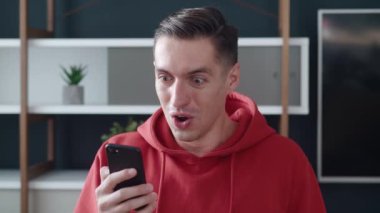 Genç adamın iyi haberler almasına çok şaşırdım. Şaşkın erkek kazananın elinde akıllı telefon var. İyi haberleri okuyun. Cep telefonuyla oynanan bahis oyunundan çok etkilendiniz..