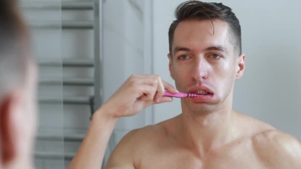 Młody człowiek myje zęby w łazience i przestaje narzekać na ból zęba. — Wideo stockowe